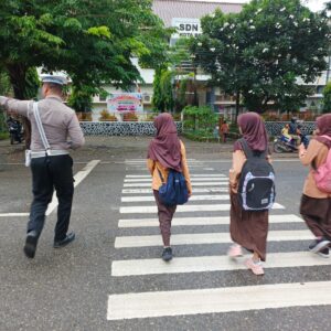 Satlantas Polres Bima Kota Aru Gatur Pagi Sambil Bantu Anak Sekolah Menyebrang Jalan